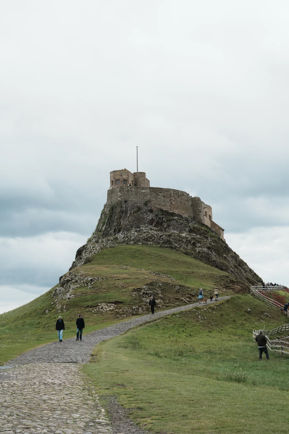 Visitors following the path toward Lindisfarne Castle